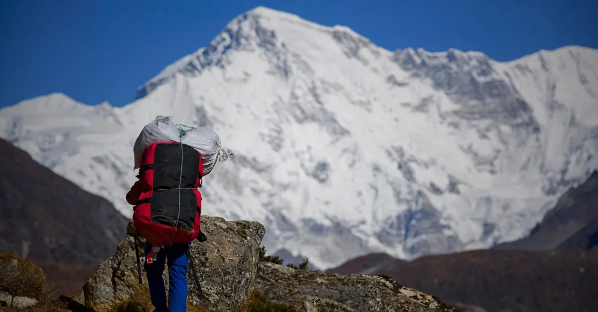 porteur au Népal sur sentier de trek Himalaya avec charge